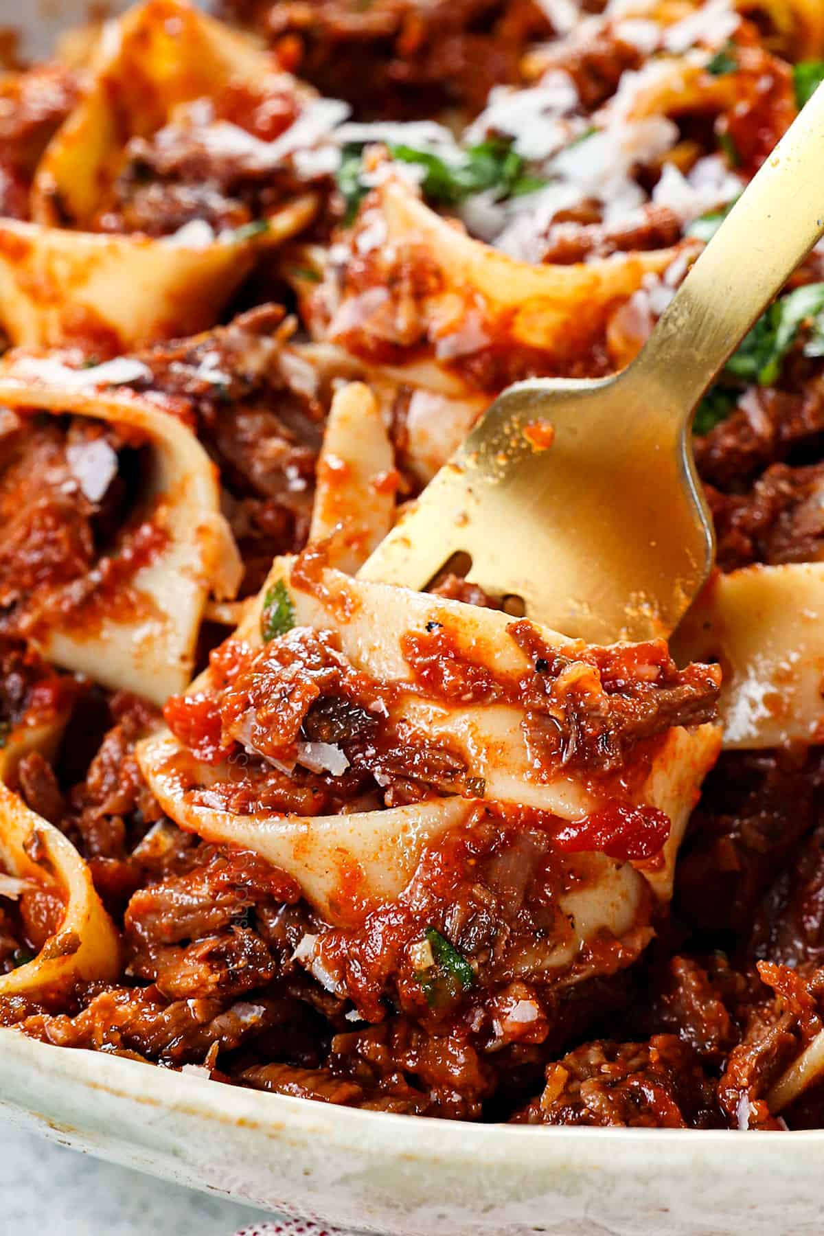 up close of twirling beef ragu with pappardelle on fork