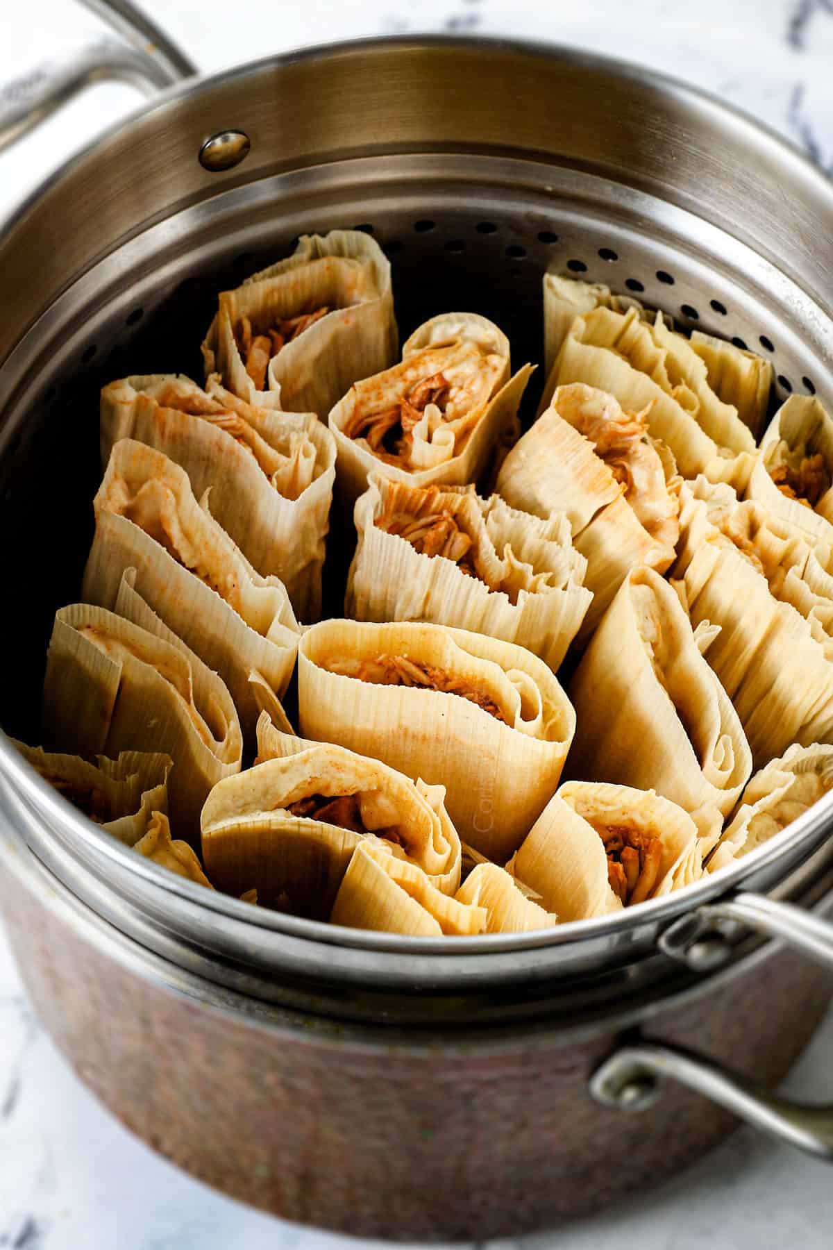 showing how to make tamales by steaming in a pot