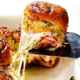 up close of ham and cheese sliders made with Hawaiian rolls baked in a 9x13 casserole dish