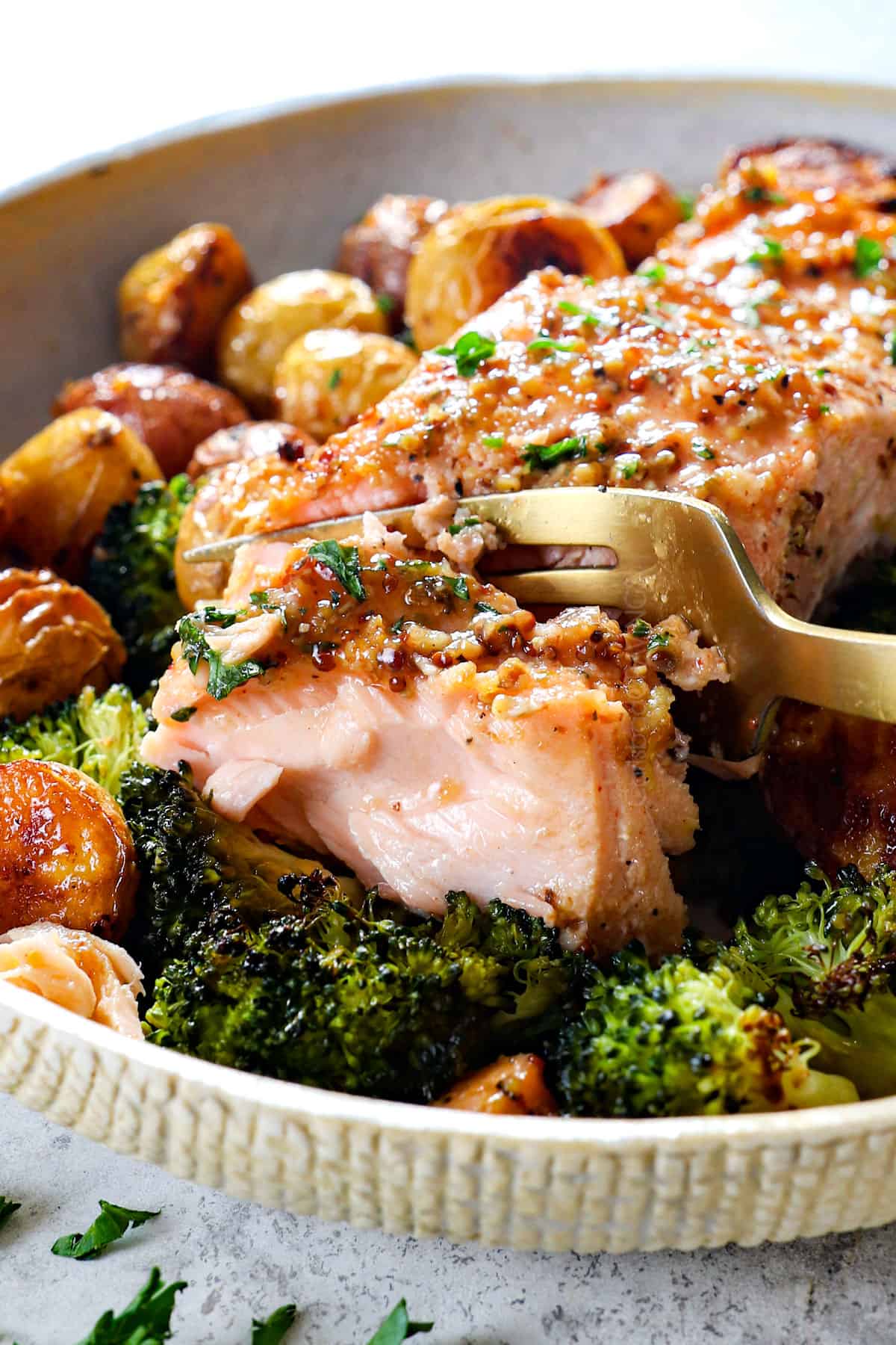 up close of taking a bite of honey mustard salmon showing how juicy and flaky it is