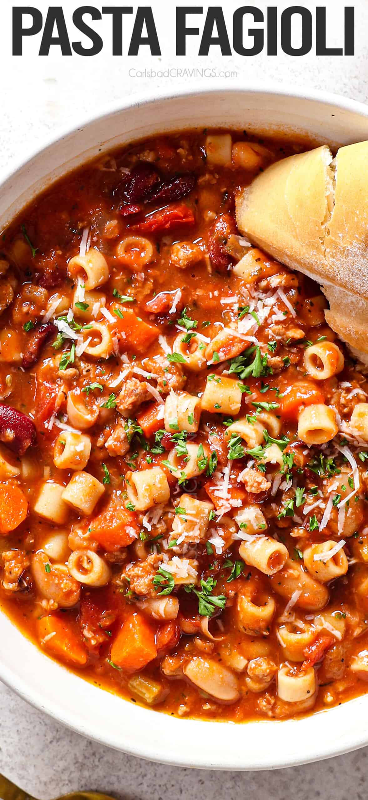 top view of a bowl of pasta fagioli soup served with crusty bread