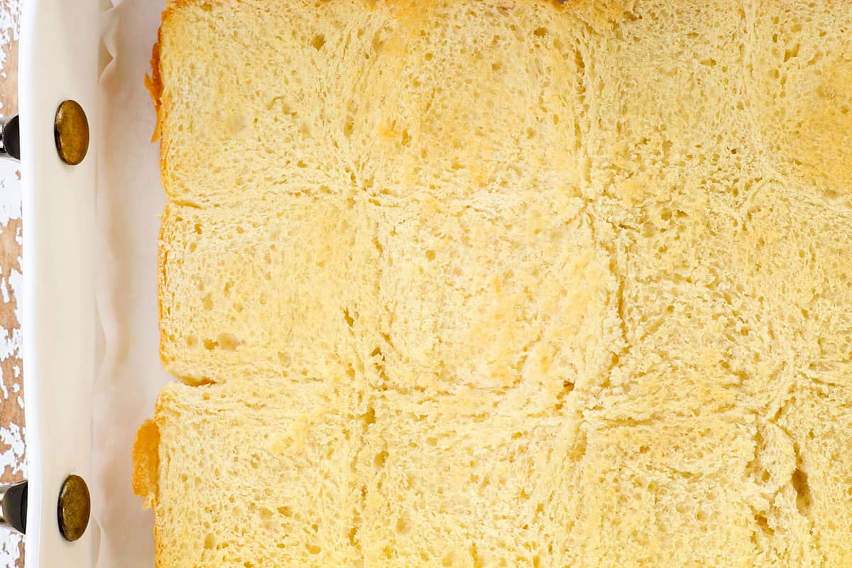 showing how to make hot ham and cheese sliders by toasting the bottom of the buns