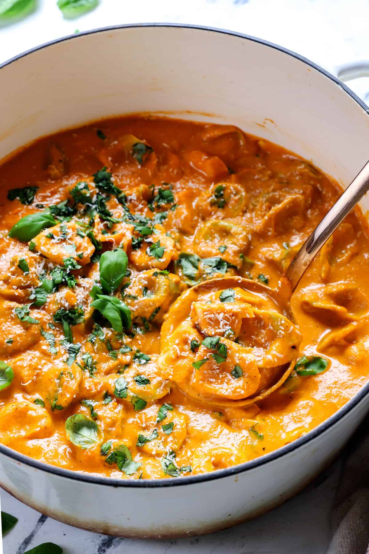 tomato tortellini soup in a pot with creamy tomato broth