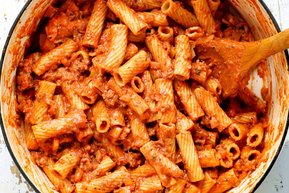 showing how to make easy baked rigatoni recipe (rigatoni al forno) by adding rigatoni to the sauce before baking