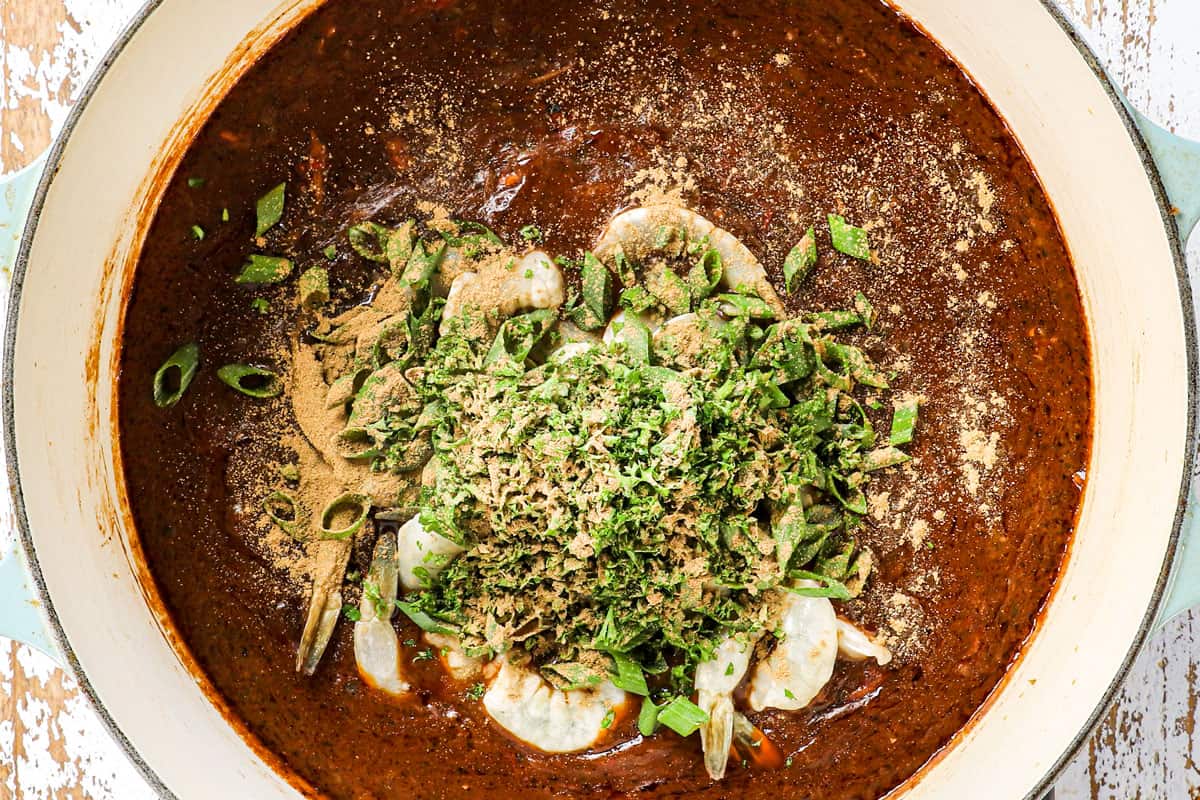 showing how to make gumbo by adding shrimp, green onions and file powder to the soup