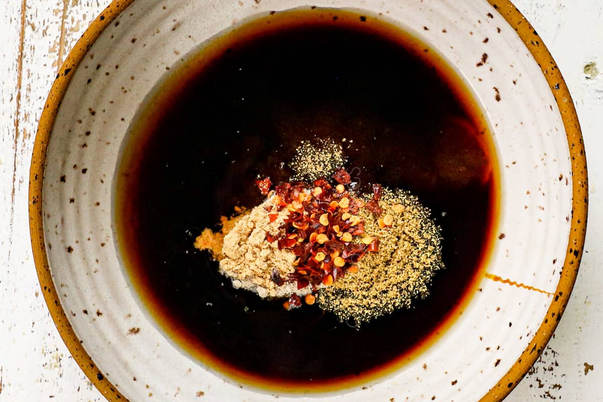 showing how to make pad woon sen by whisking the stir fry sauce ingredients together in a bowl