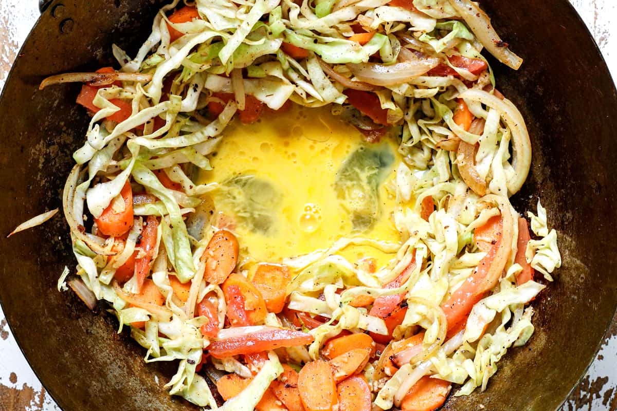 showing how to make Pad Woon Sen recipe by scrambling the eggs in the middle of the pan