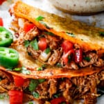 up close of baked chicken tacos showing how crispy the taco shells are and how juicy the chicken is