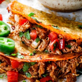 up close of baked chicken tacos showing how crispy the taco shells are and how juicy the chicken is