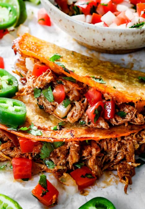 up close of baked chicken tacos showing how crispy the taco shells are and how juicy the chicken is