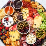 showing how to make a charcuterie board by adding crackers and bread/crostini to the board