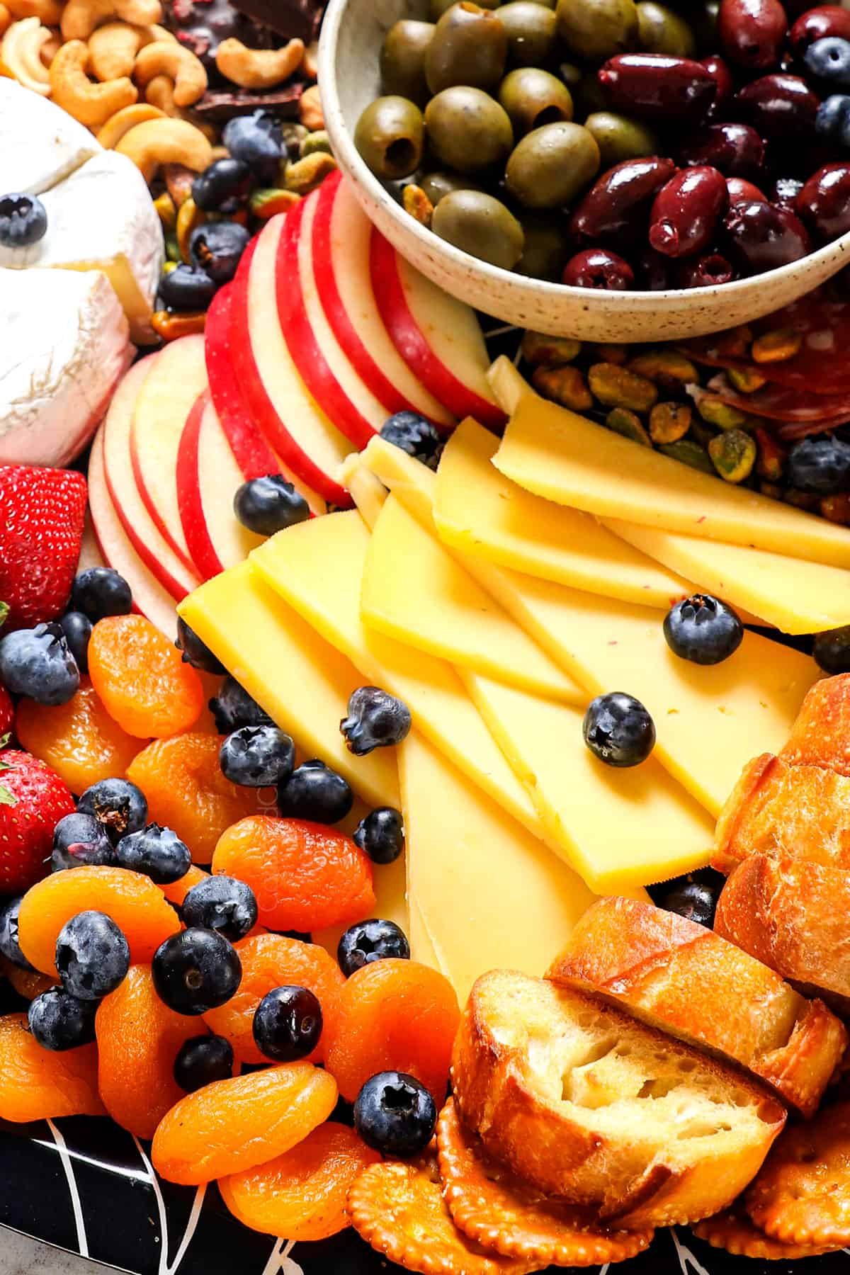 up close of fruit, cheeses and crackers on the charcuterie board
