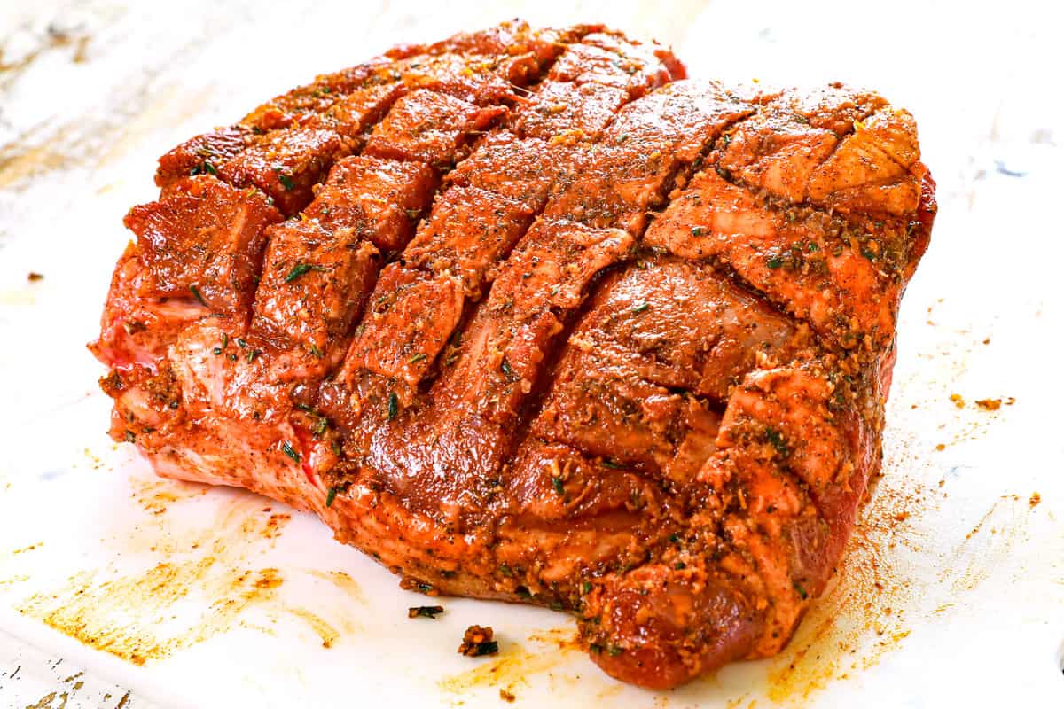 showing how to cook leg of lamb by seasoning the lamb with rosemary and garlic