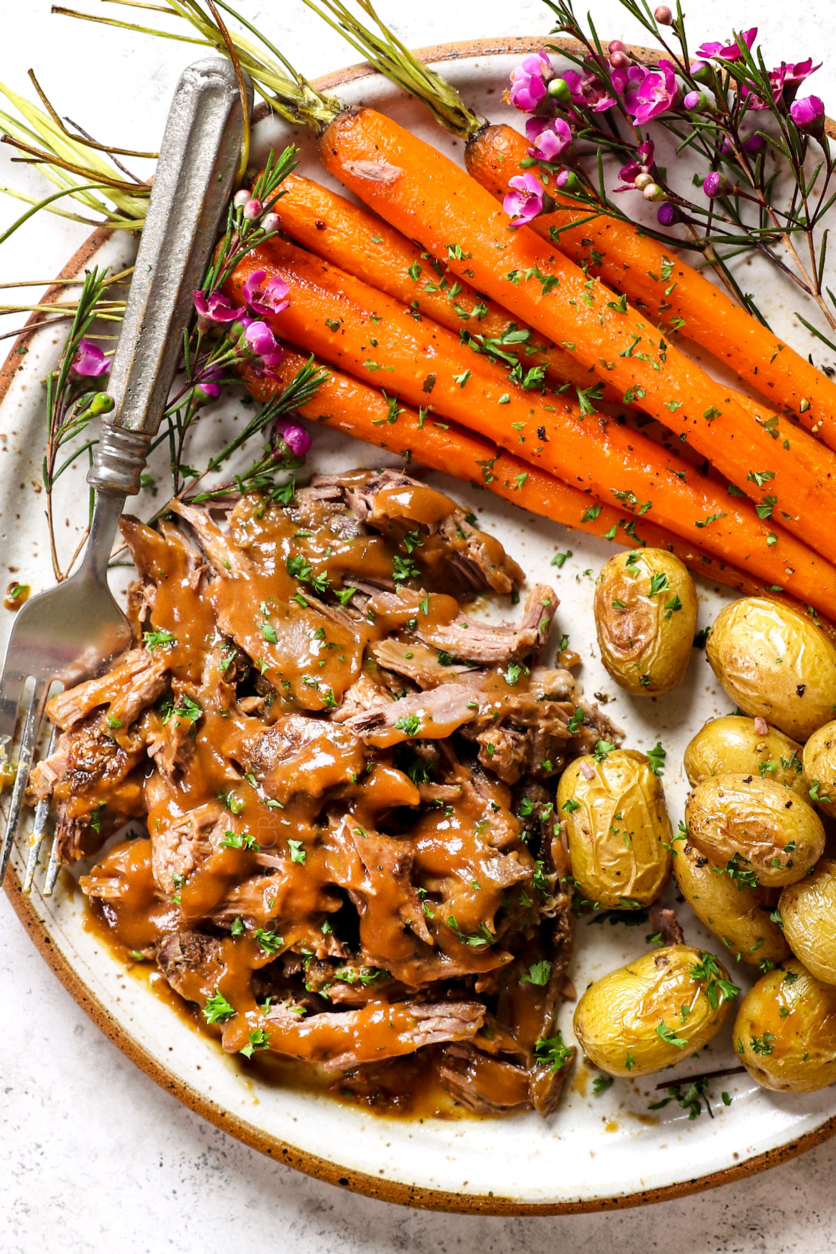showing how to serve roast leg of lamb by shredding lamb and serving it with gravy