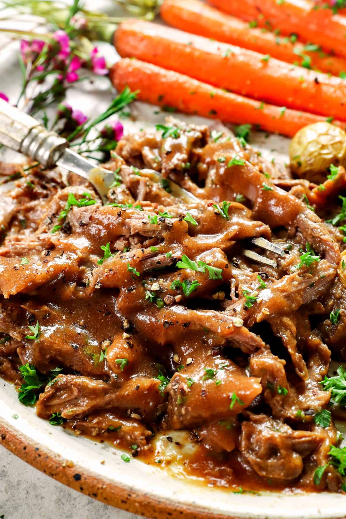 up close of shredded leg of lamb with gravy showing how juicy it is