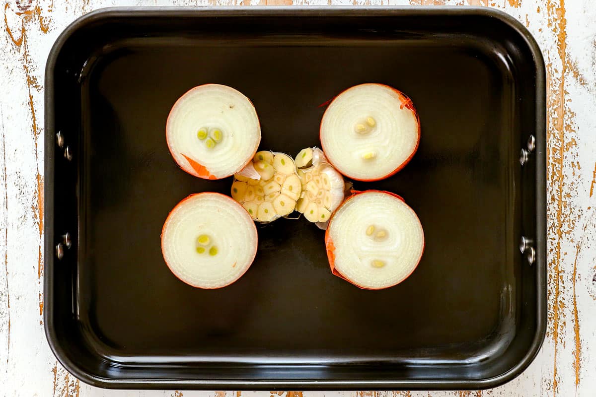 showing how to cook leg of lamb by adding onions and garlic to a roasting pan