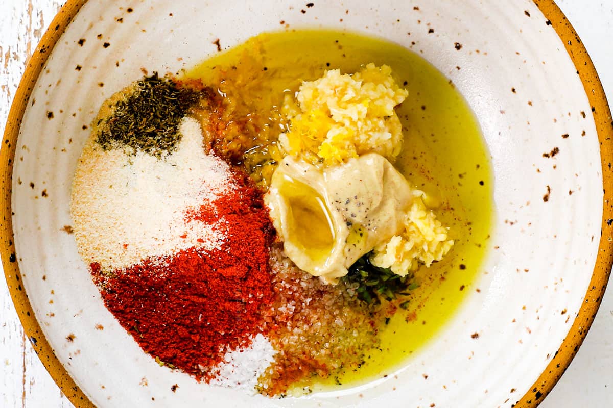 showing how to cook leg of lamb by making a wet rub with fresh rosemary, thyme, paprika, chili powder, olive oil, Dijon, maple,