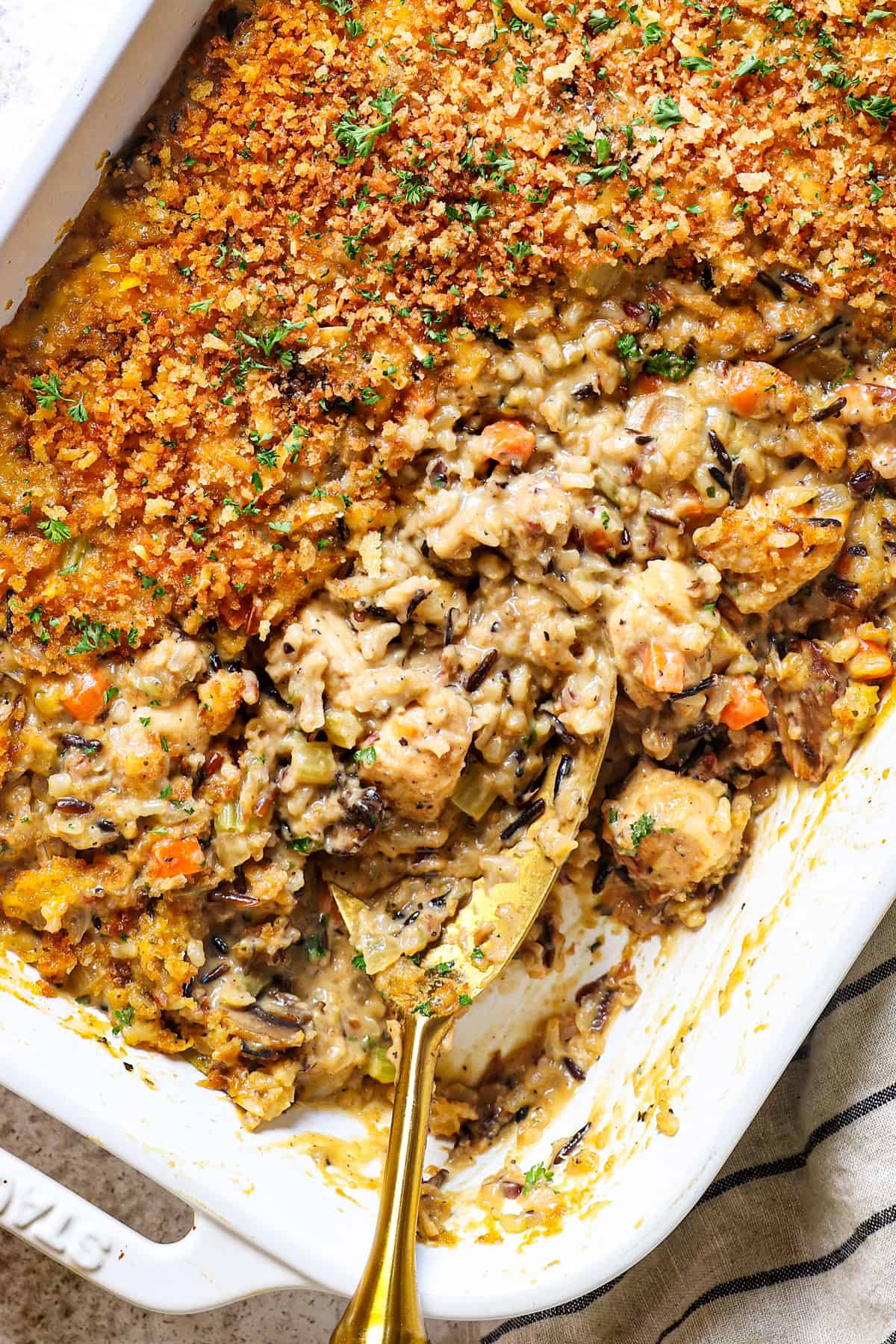 top view of chicken and wild rice casserole with mushrooms, carrots, celery and wild rice in a from scratch cream sauce topped with panko