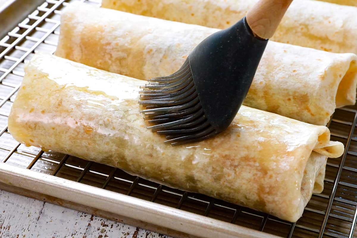 showing how to make beef chimichangas by brushing the tortillas with oil before baking and air frying