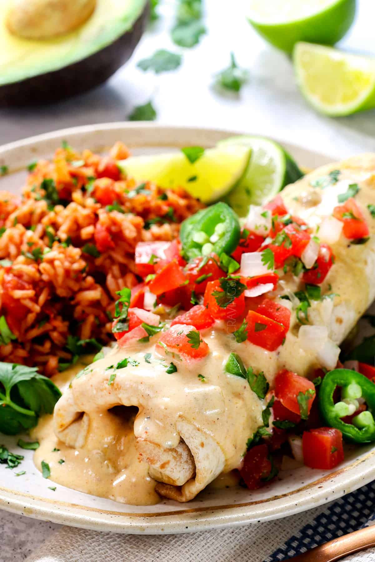 showing how to serve chimichanga recipe with beef by topping with pico de gallo and jalapenos with a side of Mexican rice