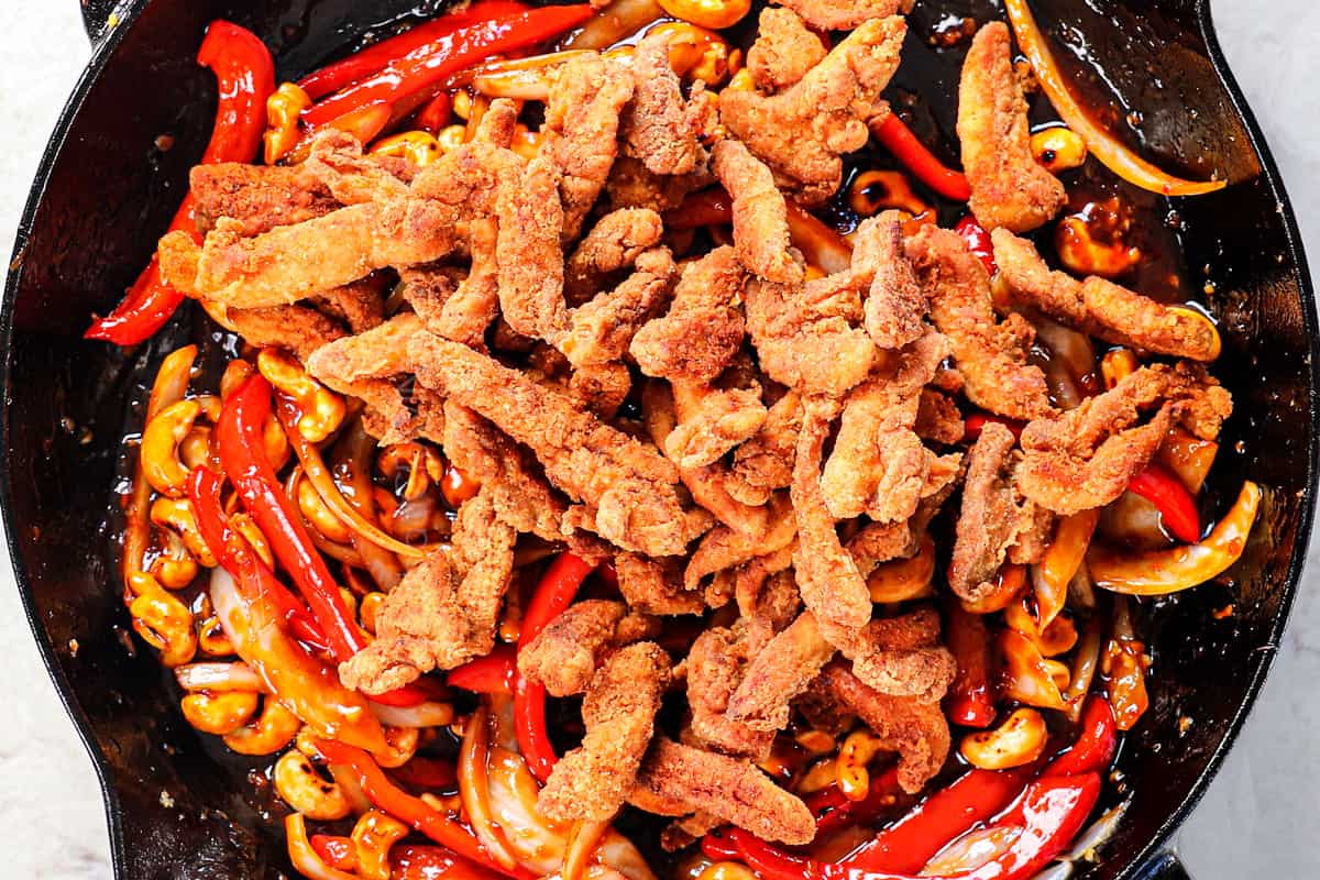 showing how to make spicy Dragon Chicken by adding the chicken strips to the sauce and turning to coat