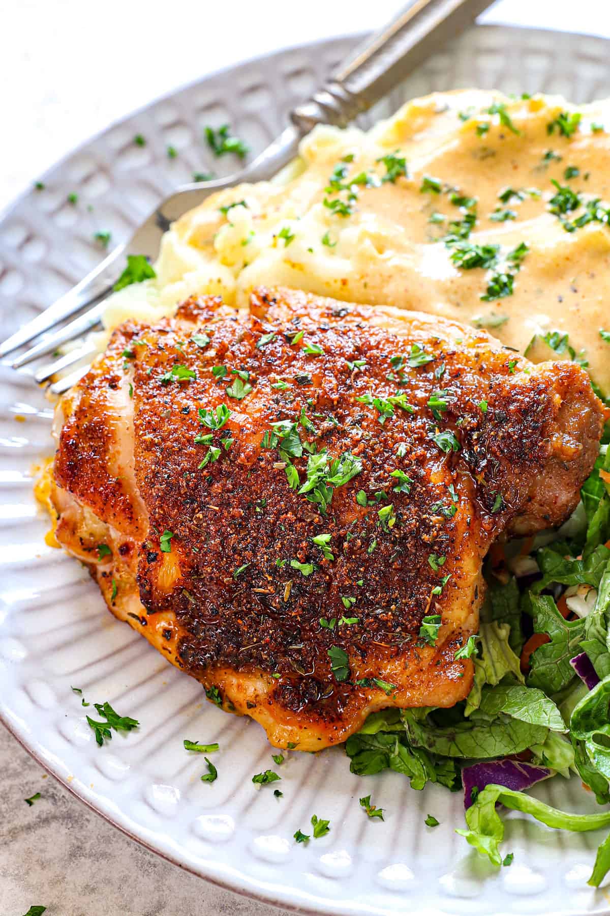 baked chicken thighs in oven being served on a plate with mashed potatoes