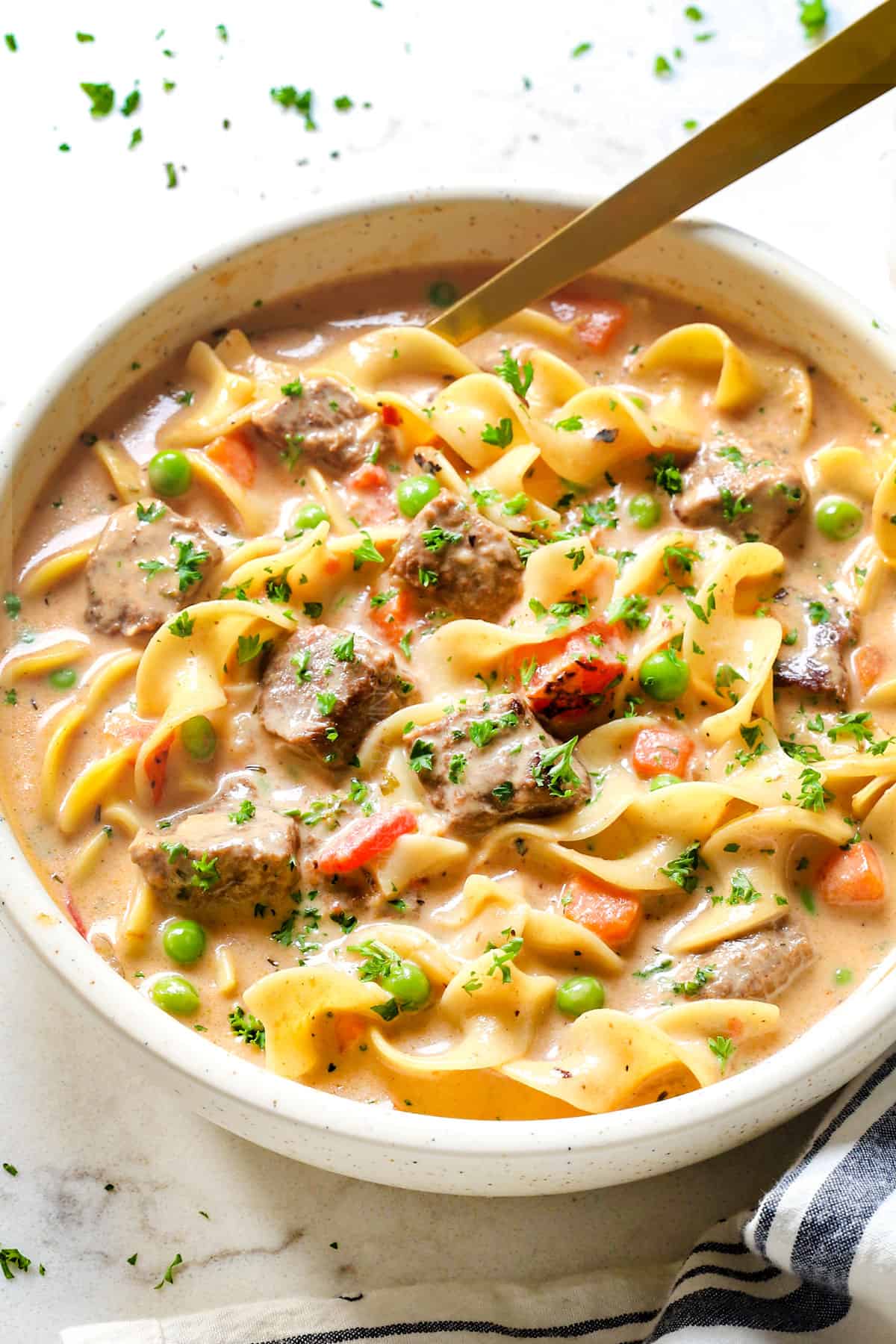 showing how to make beef noodle soup in a bowl garnished with parsley