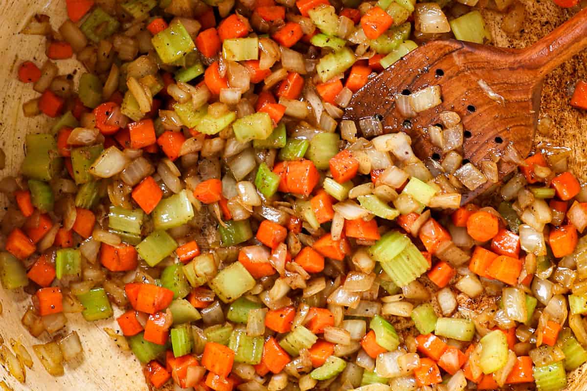 showing how to make Beef Noodle Soup by sautรฉing onions, carrots and celery until onions are softened