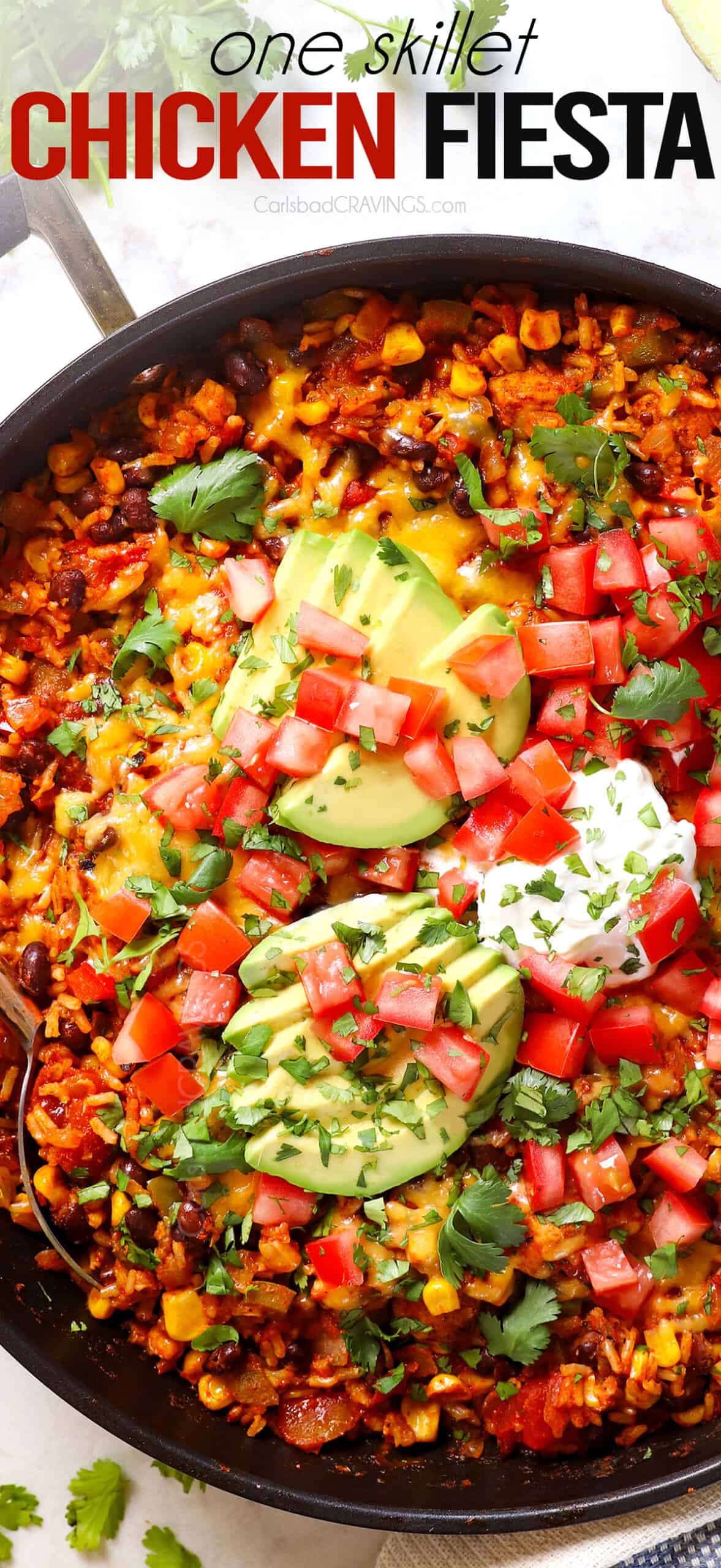 top view of Chicken Fiesta in a skillet topped with avocados and tomatoes