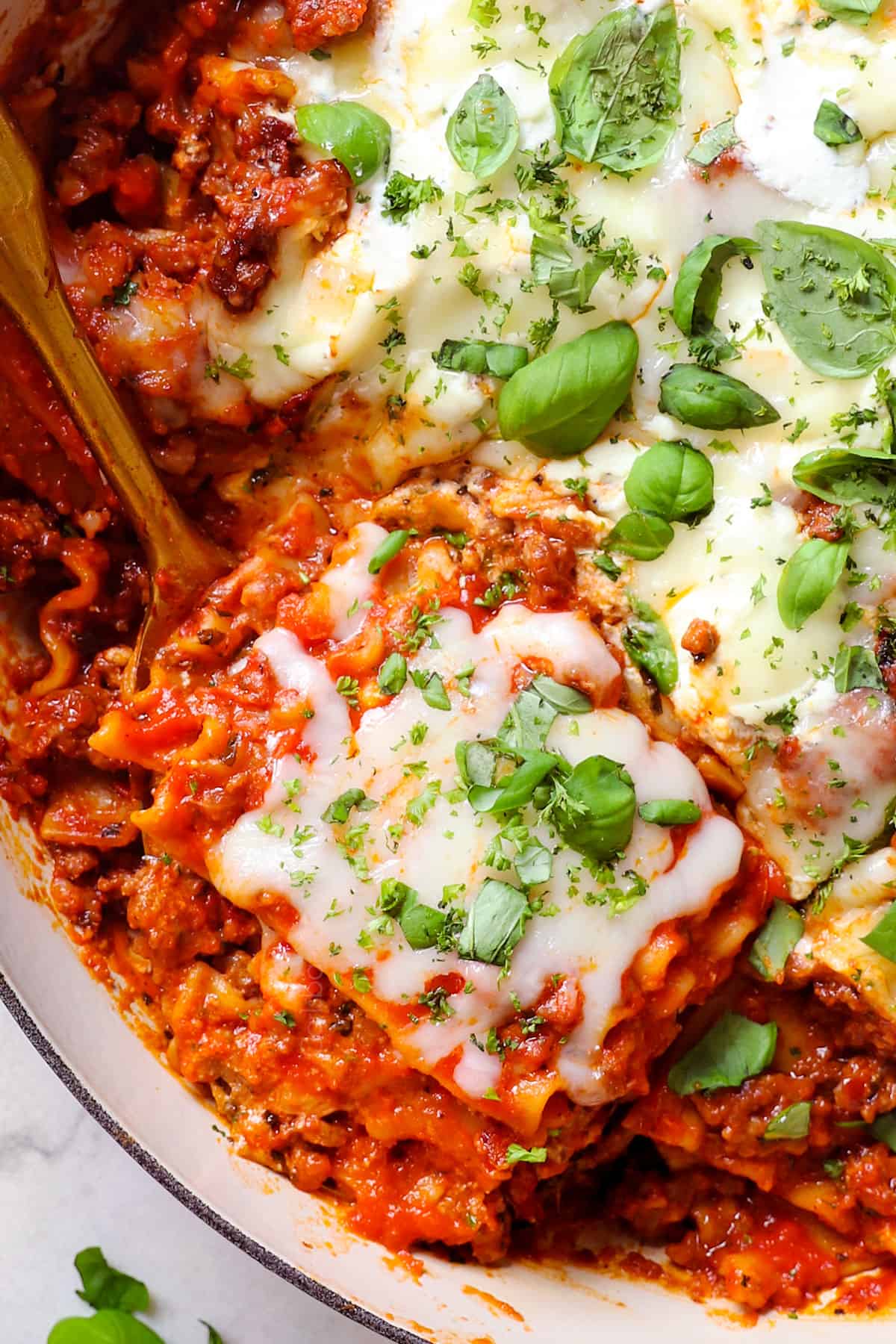 up close top view of easy lasagna skillet topped with fresh basil showing how cheesy it is