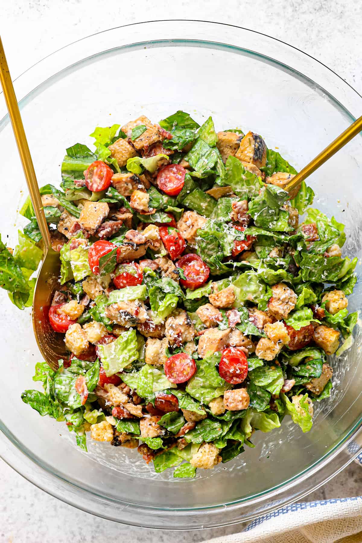 showing how to make Chicken Caesar Wrap by stirring chicken, lettuce, tomatoes, croutons and Parmesan together in a bowl