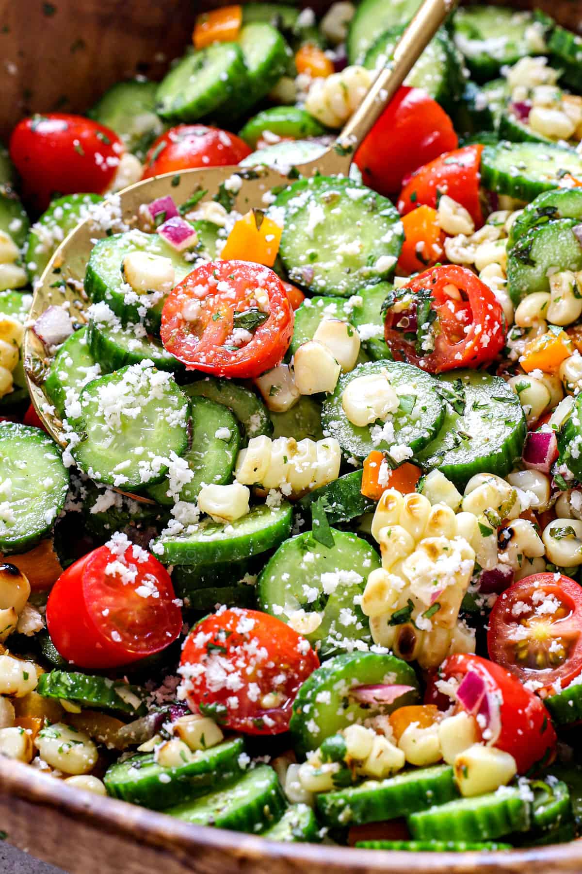 up close of making cucumber salad by tossing with dressing