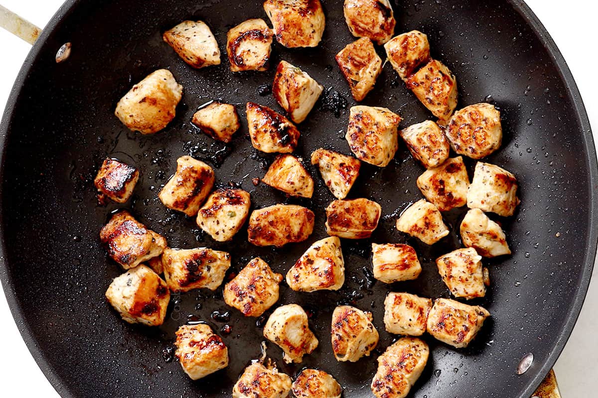 showing how to make chicken pasta salad by cooking chicken in a skillet