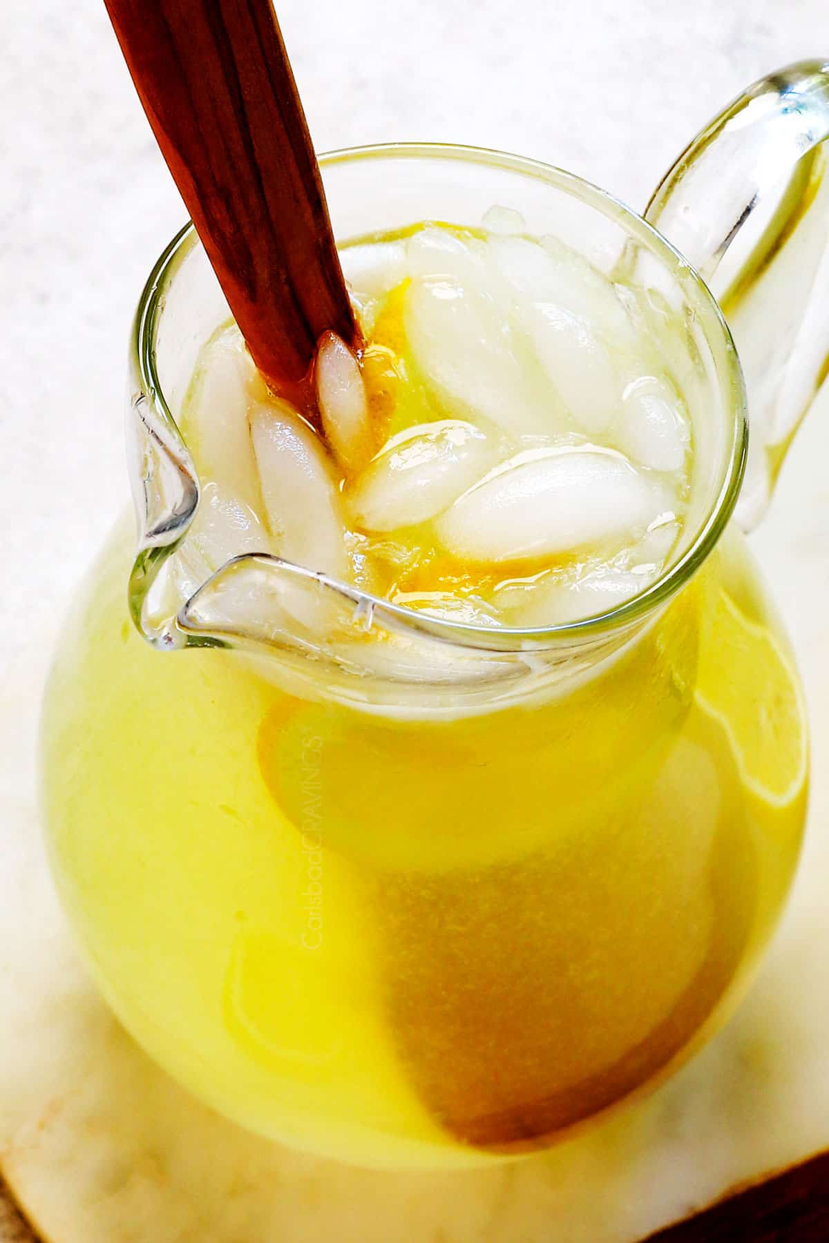 showing how to make best lemonade recipe by stirring ice into the lemonade before serving