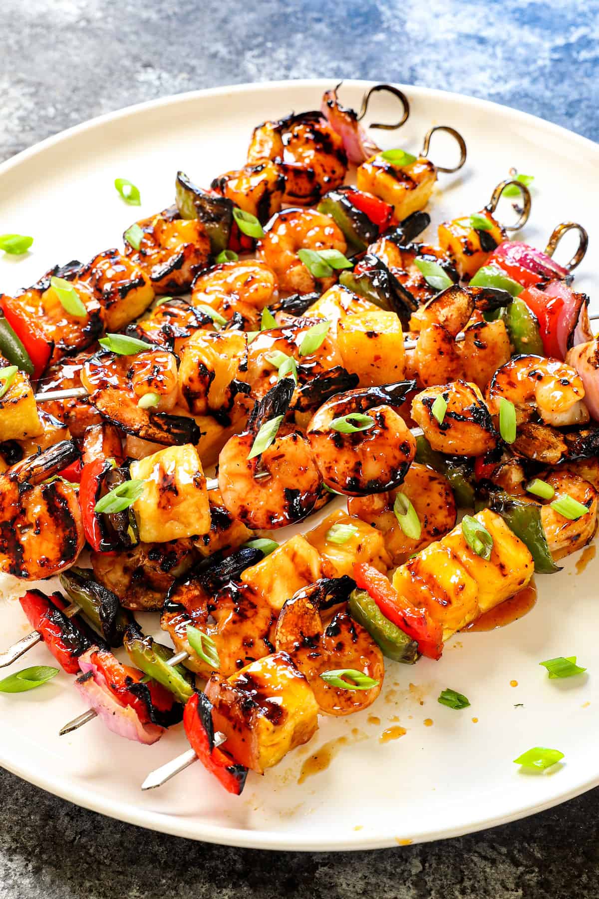 shrimp skewers stacked on a plate showing how juicy the shrimp is