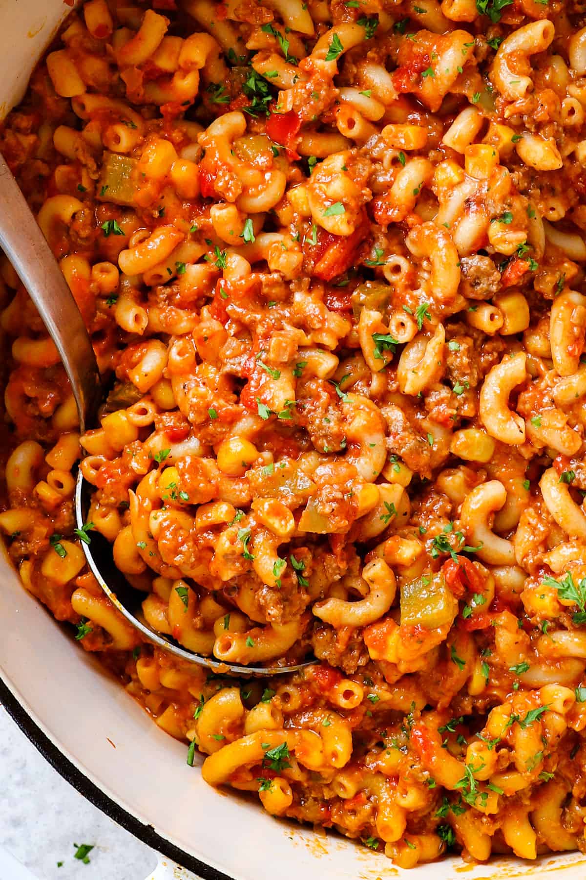 showing how to make goulash (American Chop Suey) by stirring the cheese into the pasta and beef