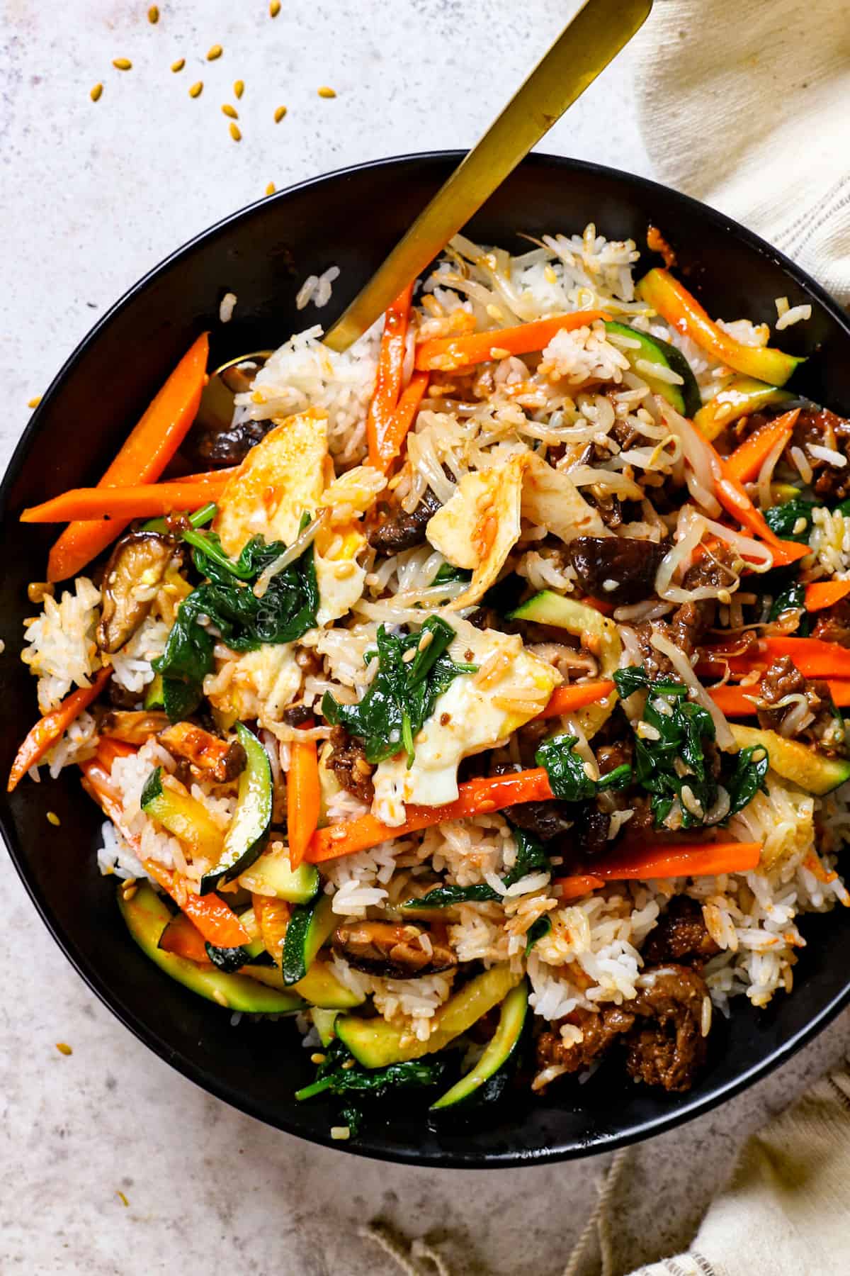 showing how to eat bibimbap by tossing the ingredients together with chopsticks