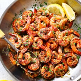 showing how to make Cajun shrimp recipe by tossing sautรฉed shrimp with butter and parsley