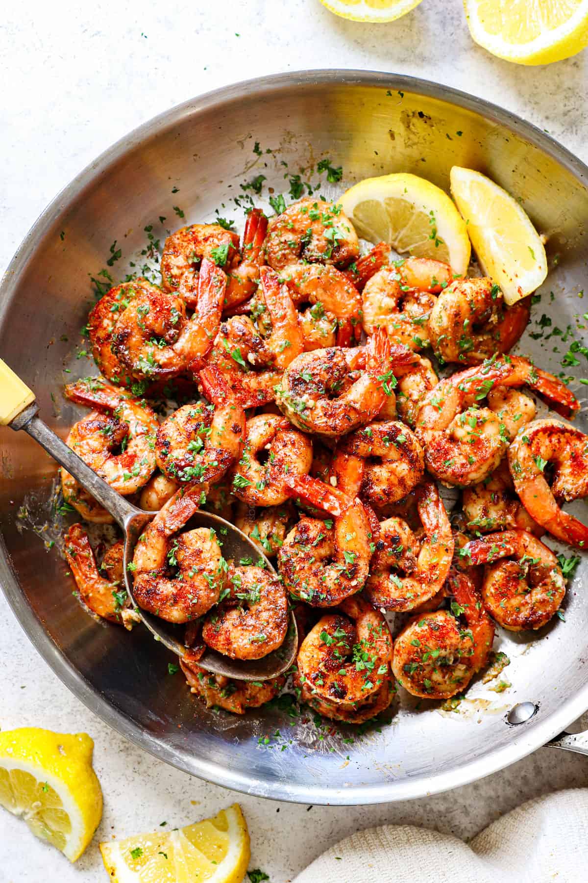 showing how to make Cajun shrimp recipe by tossing sautรฉed shrimp with butter and parsley