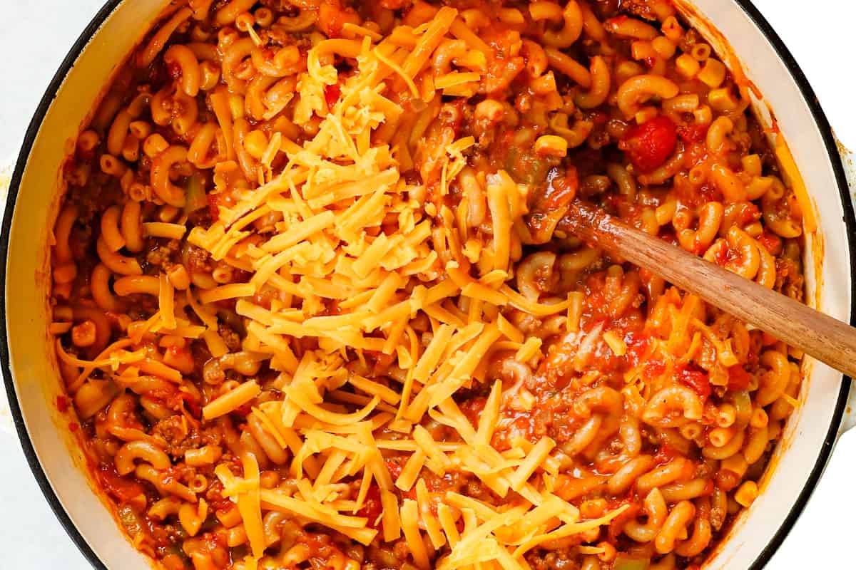showing how to make goulash by stirring in cheese a handful at a time
