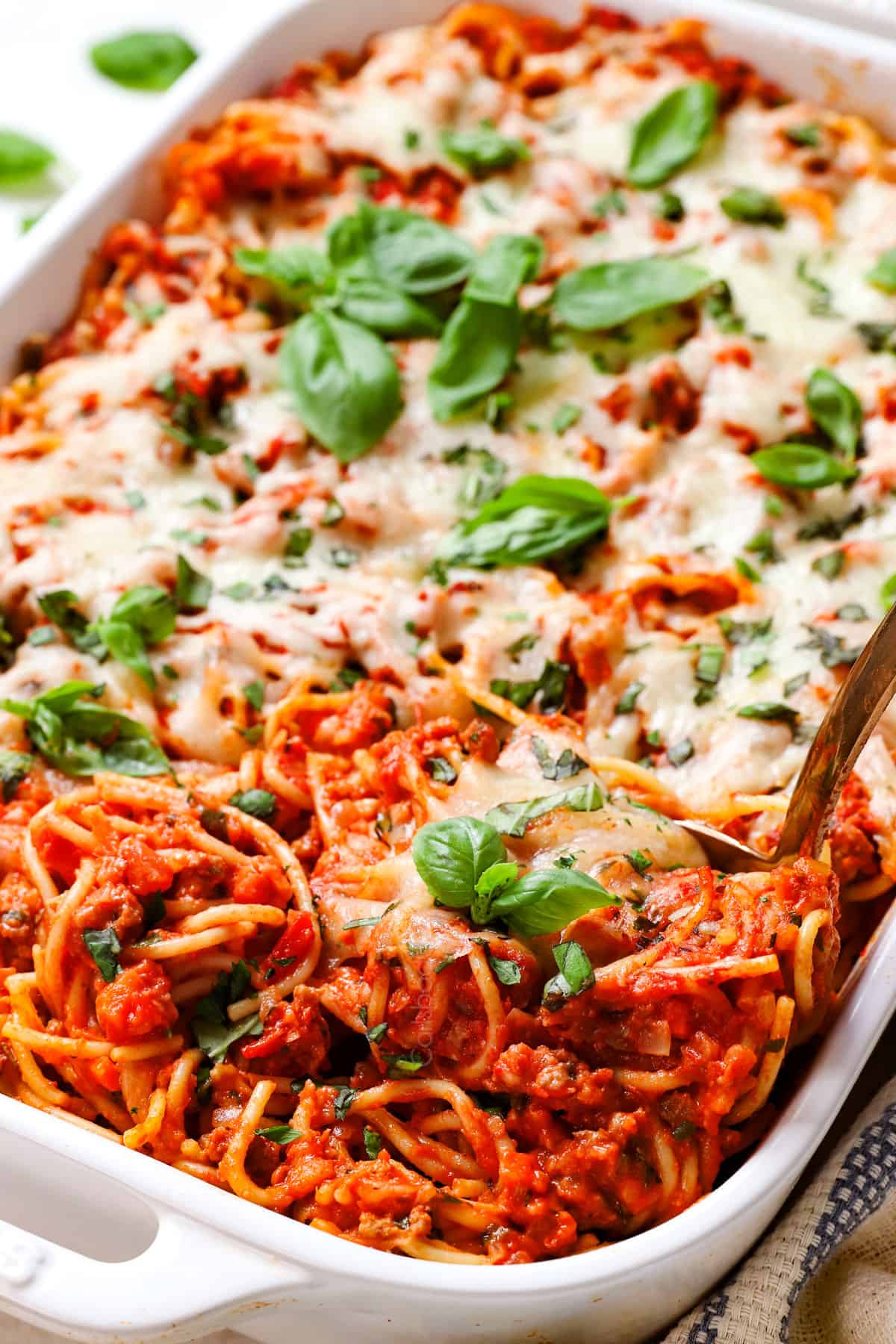showing how to make baked spaghetti by baking in the oven until the cheese is melted