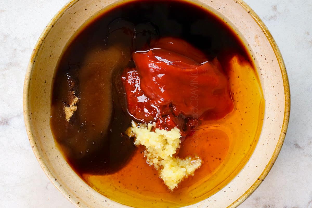 showing how to make Korean fried chicken (yangnyeom) by whisking the yangnyeom sauce together in a bowl