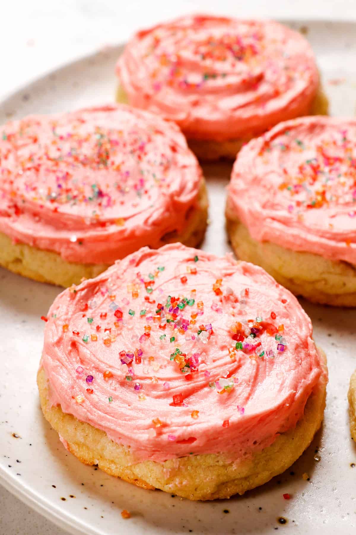 showing how to decorate homemade sugar cookies on a plate with frosting