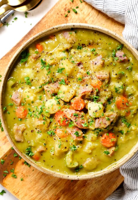 showing how to serve split pea soup with ham by adding to a bowl and garnishing with parsley