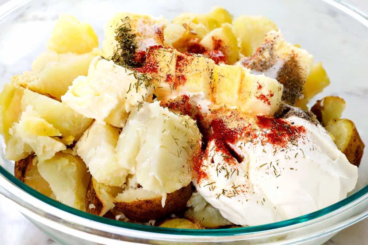 showing how to make twice baked potato casserole by adding potatoes, milk, sour cream and seasonings to a bowl