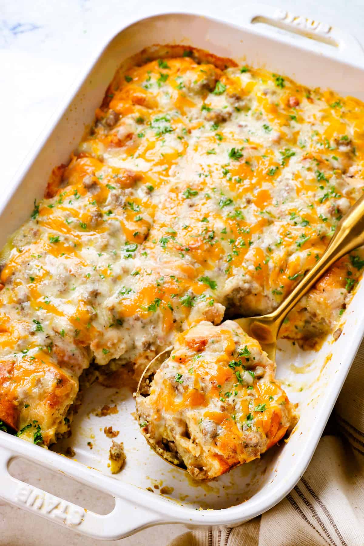 showing how to serve biscuit and gravy casserole by garnishing with parsley