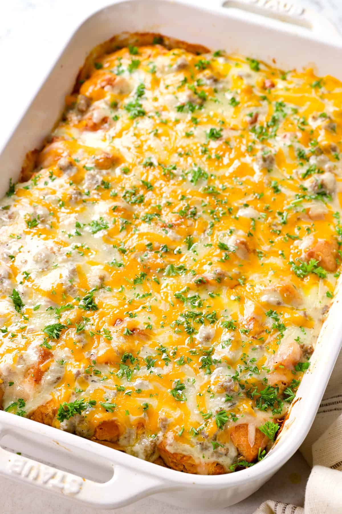 showing how to make biscuits and gravy casserole by baking until the cheese melts