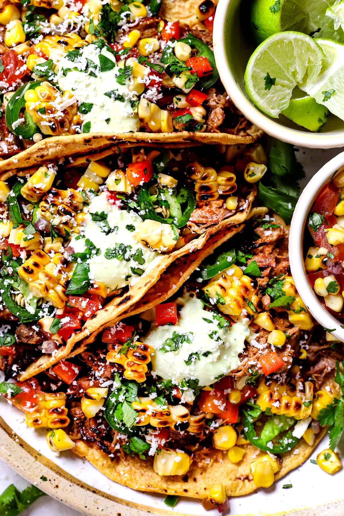 pork carnitas tacos being served with cilantro, salsa and pic de gallo