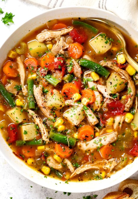 showing how to serve chicken vegetable soup in a bowl garnished with parsley