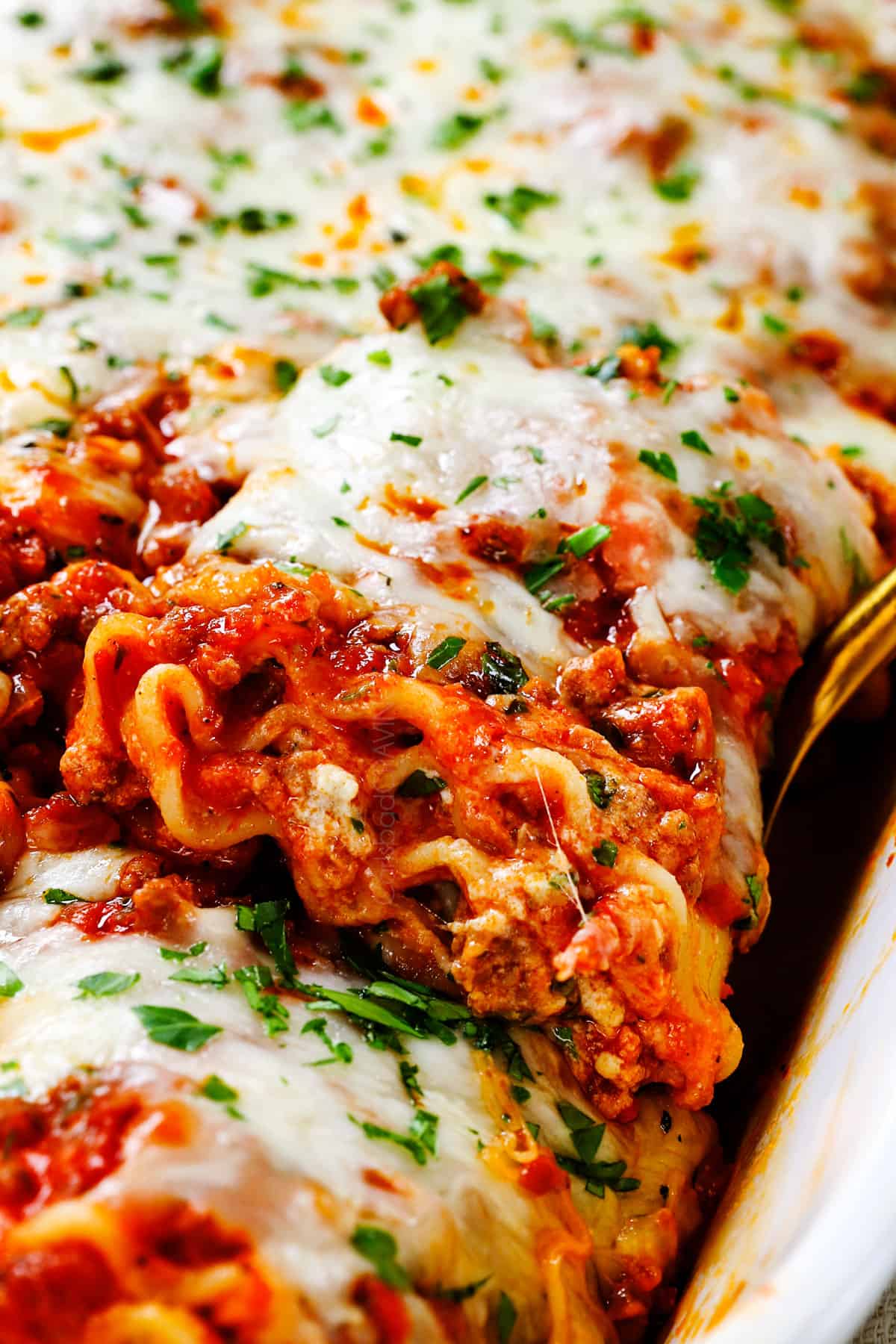 up close of scooping up a lasagna roll up with a spoon